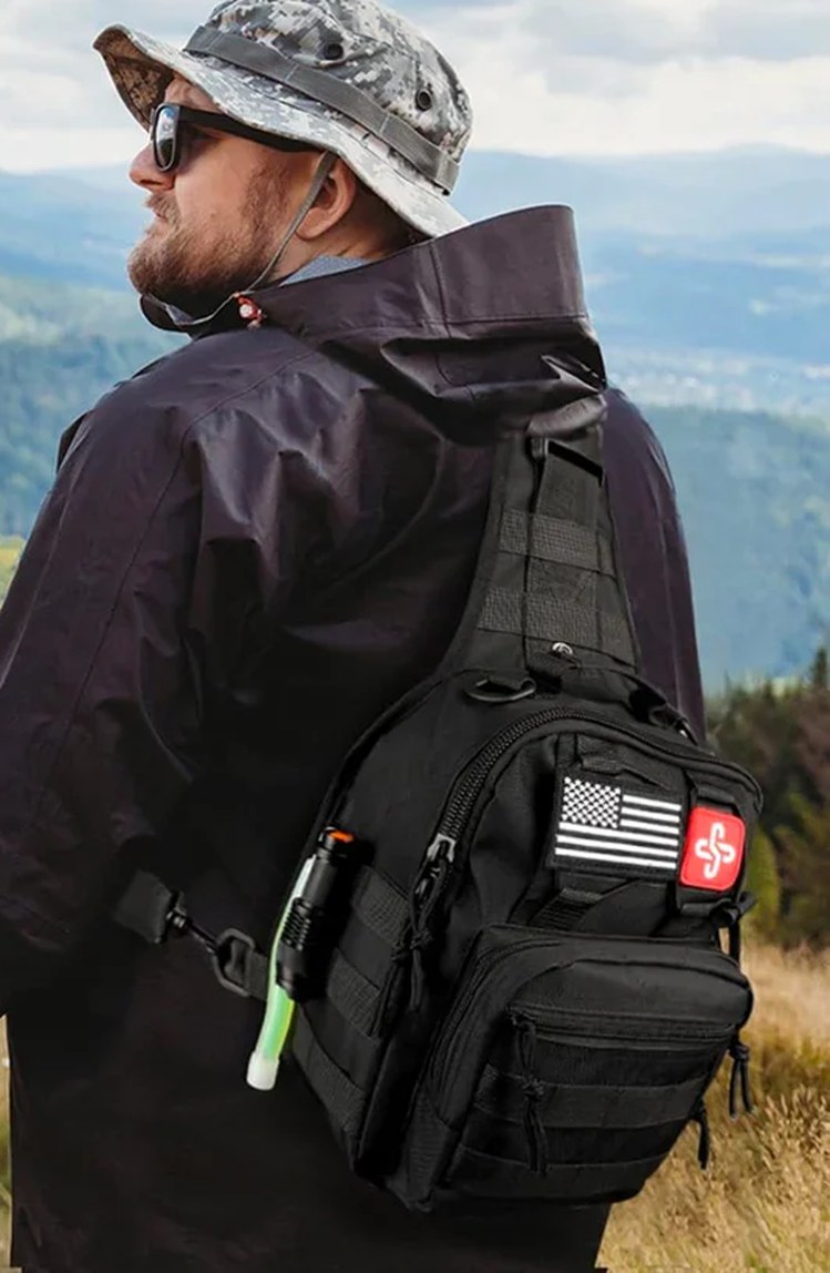 Hiker on a mountain trail wearing the tactical survival sling pack on his back